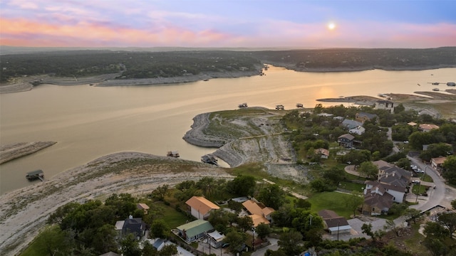 aerial view at dusk featuring a water view