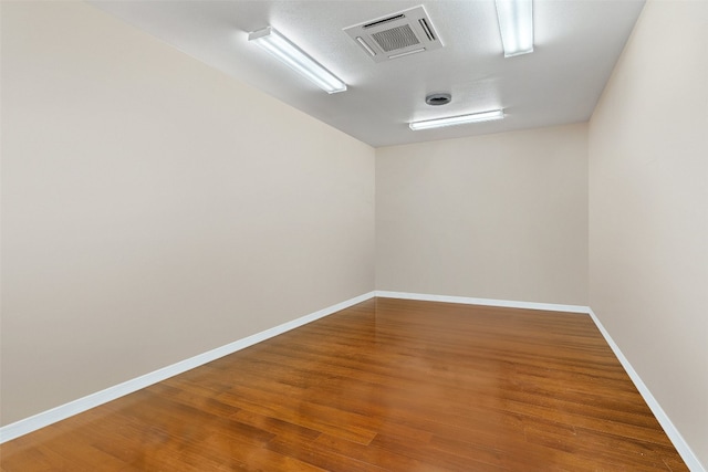 empty room with hardwood / wood-style floors and a textured ceiling