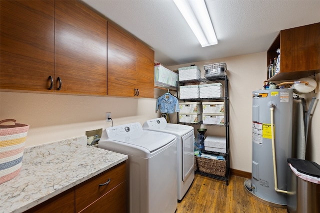 clothes washing area featuring cabinets, dark hardwood / wood-style flooring, washing machine and clothes dryer, hookup for a washing machine, and electric water heater