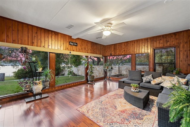 sunroom featuring beam ceiling and ceiling fan