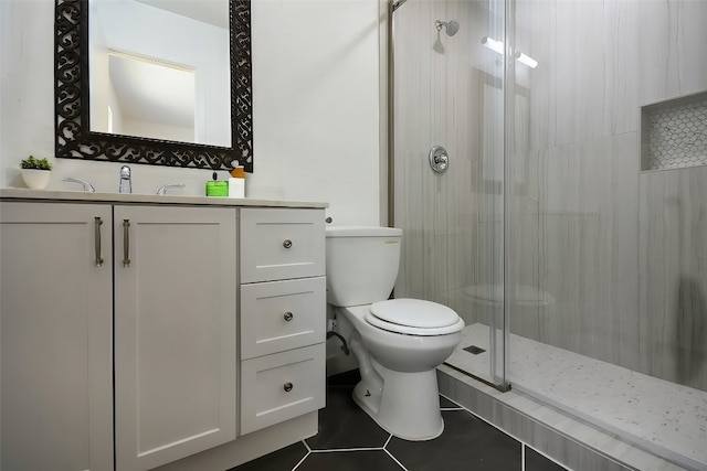 bathroom with vanity, tile patterned flooring, toilet, and a shower with door