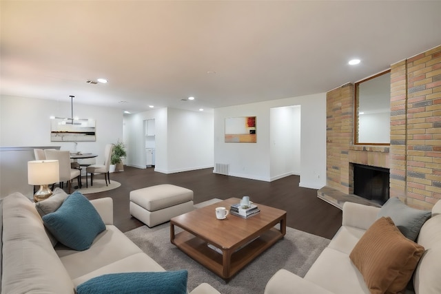 living room featuring a brick fireplace and hardwood / wood-style flooring