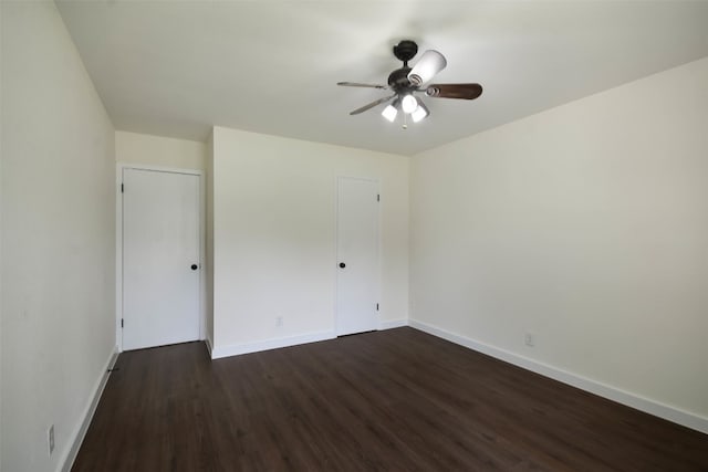 empty room featuring ceiling fan and dark wood-type flooring