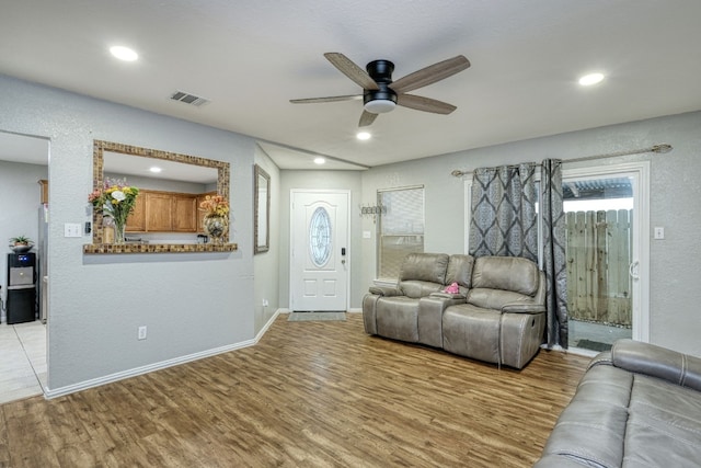 living room featuring light wood-type flooring and ceiling fan