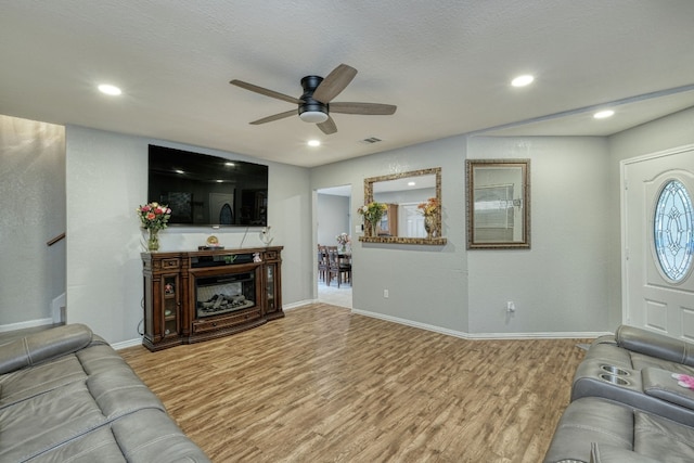 living room featuring ceiling fan and light hardwood / wood-style floors