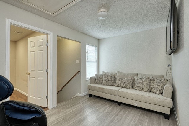 living room with a textured ceiling and wood-type flooring