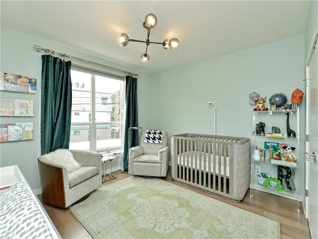 bedroom with a nursery area and hardwood / wood-style floors