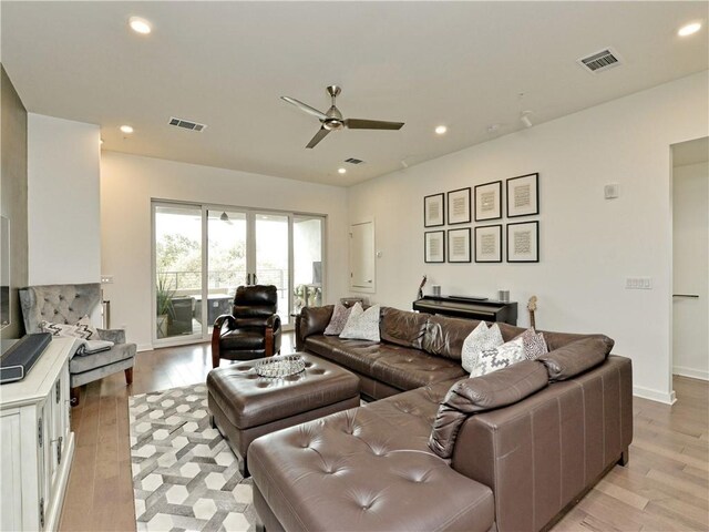 living room featuring ceiling fan and light hardwood / wood-style flooring