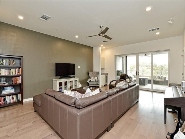 living room with light wood-type flooring, french doors, and ceiling fan