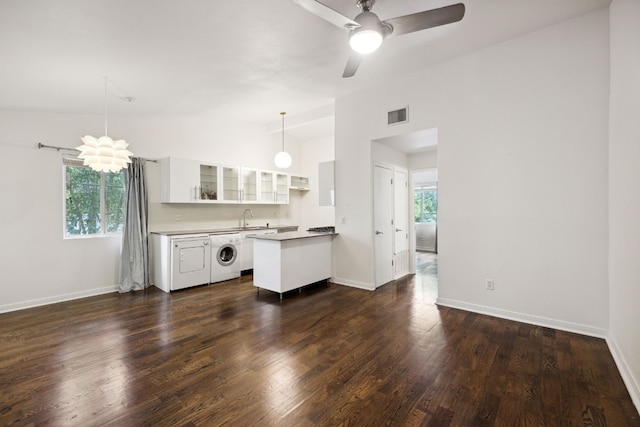 kitchen with dark hardwood / wood-style flooring, washer / clothes dryer, ceiling fan, white cabinets, and lofted ceiling