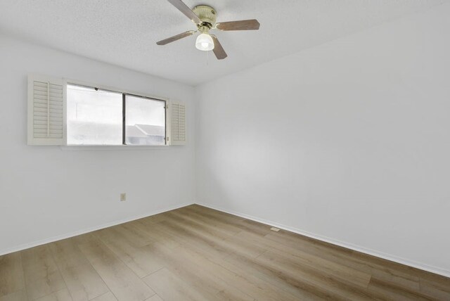 spare room with hardwood / wood-style flooring, ceiling fan, and a textured ceiling