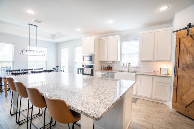 kitchen featuring pendant lighting, a barn door, and a kitchen island