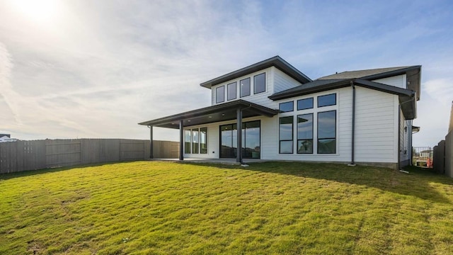 rear view of property with a yard and a patio