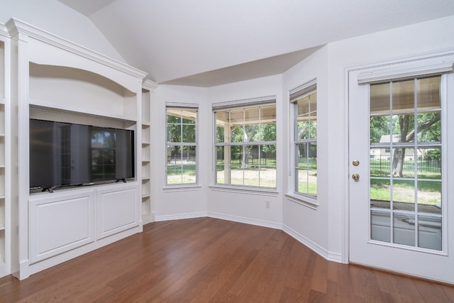 unfurnished living room featuring built in shelves, hardwood / wood-style floors, and lofted ceiling