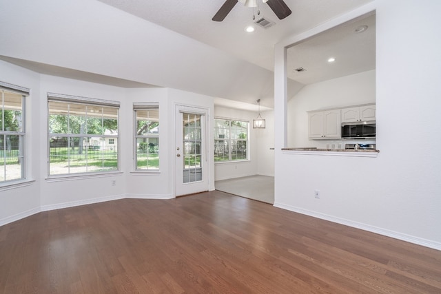 unfurnished living room featuring dark hardwood / wood-style floors, ceiling fan, and vaulted ceiling