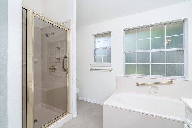 full bathroom with tile floors, plenty of natural light, shower with separate bathtub, and toilet