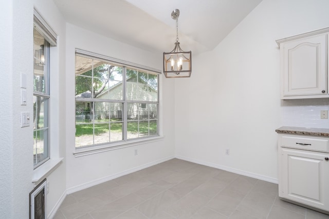 unfurnished dining area with vaulted ceiling, a wealth of natural light, a chandelier, and light tile floors