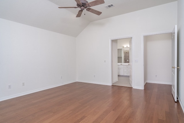 unfurnished bedroom featuring lofted ceiling, ensuite bathroom, ceiling fan, and dark hardwood / wood-style flooring