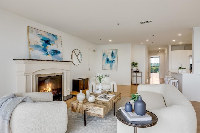 living room featuring visible vents, recessed lighting, and a premium fireplace