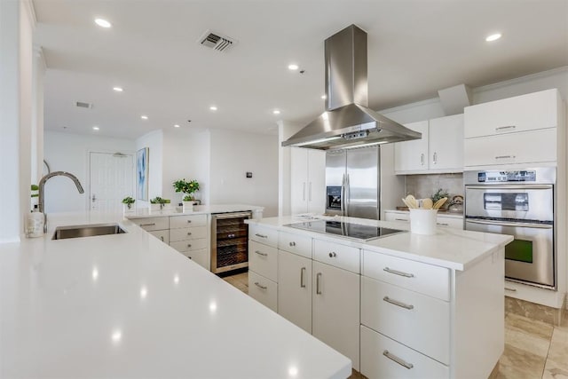 kitchen with visible vents, a sink, wine cooler, appliances with stainless steel finishes, and island range hood