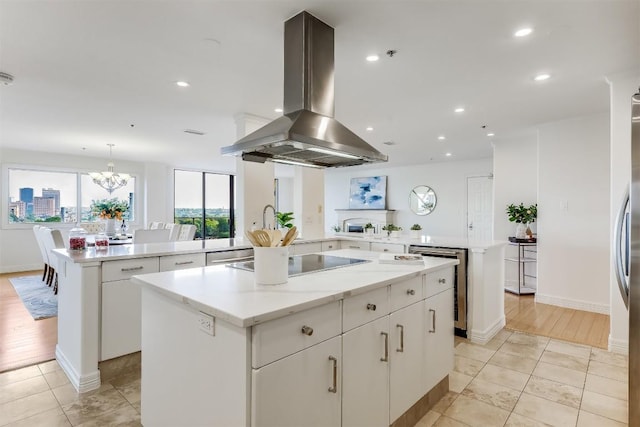 kitchen with a center island, black electric stovetop, recessed lighting, a peninsula, and island range hood