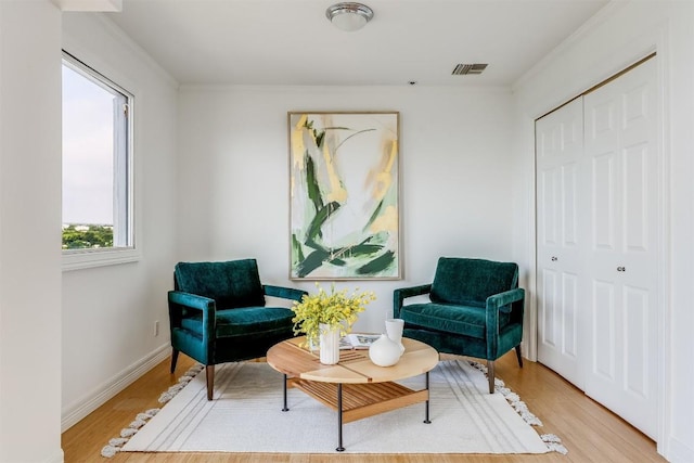 sitting room featuring visible vents, baseboards, and wood finished floors