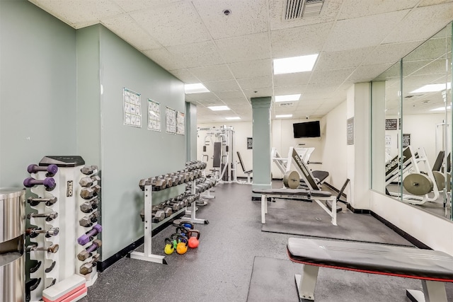 exercise room featuring baseboards, visible vents, and a drop ceiling