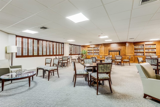 dining room featuring built in features, light colored carpet, and visible vents