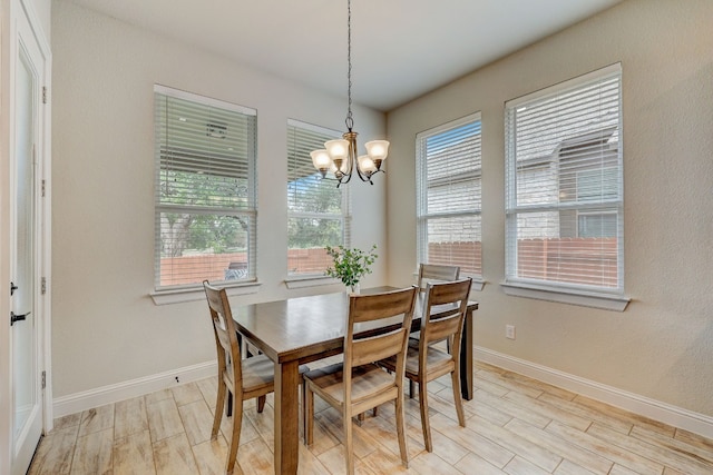 dining room with light hardwood / wood-style flooring and a notable chandelier