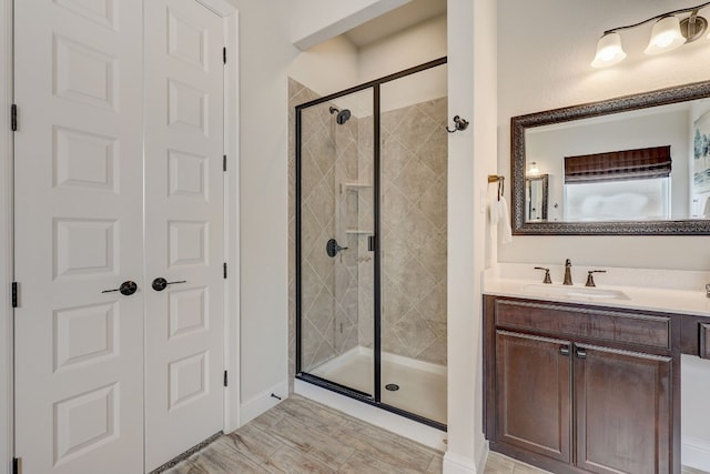 bathroom with vanity and a shower with door