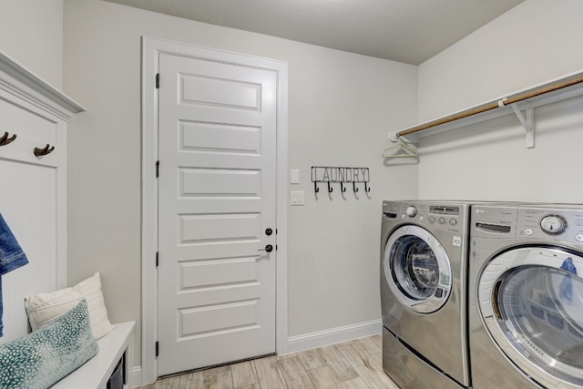 laundry room featuring washer and dryer and light hardwood / wood-style floors