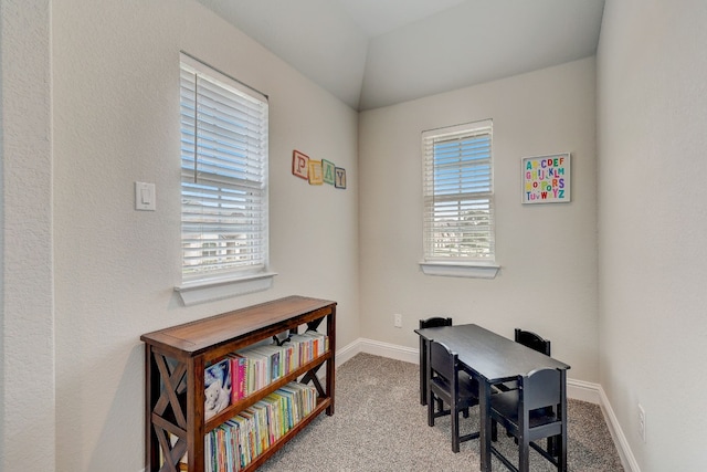 office space featuring a wealth of natural light, light colored carpet, and lofted ceiling