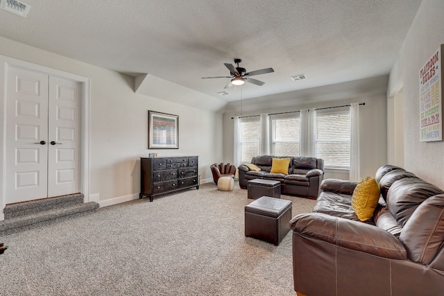 carpeted living room featuring a textured ceiling, vaulted ceiling, and ceiling fan