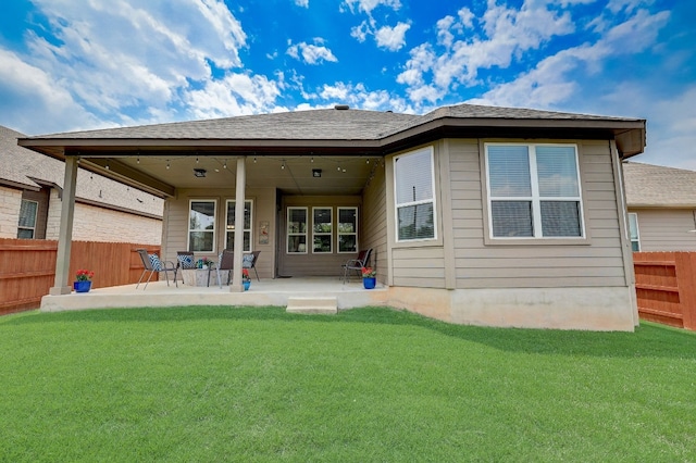 rear view of property with a yard and a patio area