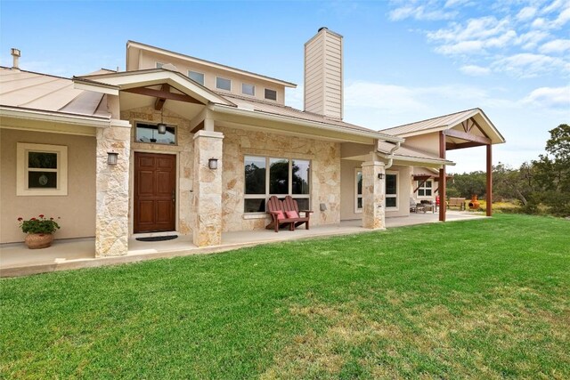 rear view of property featuring a patio area and a yard