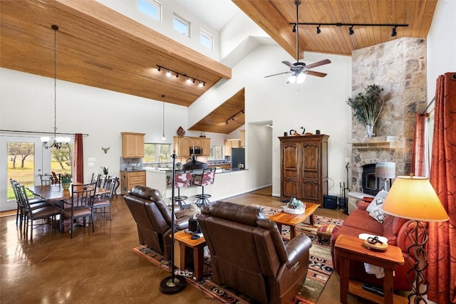 living room featuring wooden ceiling, high vaulted ceiling, ceiling fan with notable chandelier, a fireplace, and concrete floors