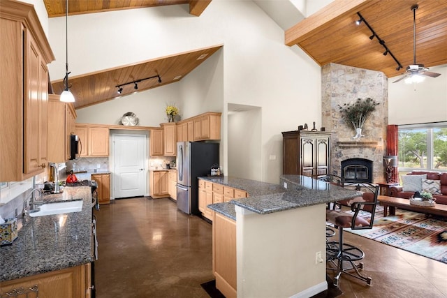 kitchen with tasteful backsplash, high vaulted ceiling, decorative light fixtures, and appliances with stainless steel finishes