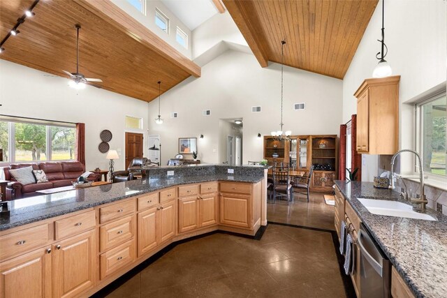 kitchen with light brown cabinets, a towering ceiling, sink, and hanging light fixtures