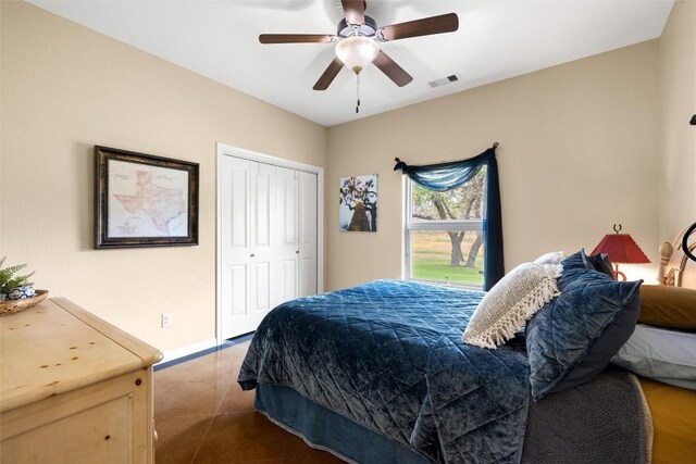 tiled bedroom featuring ceiling fan and a closet