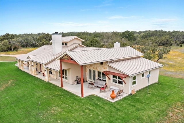 rear view of house featuring a patio area and a lawn