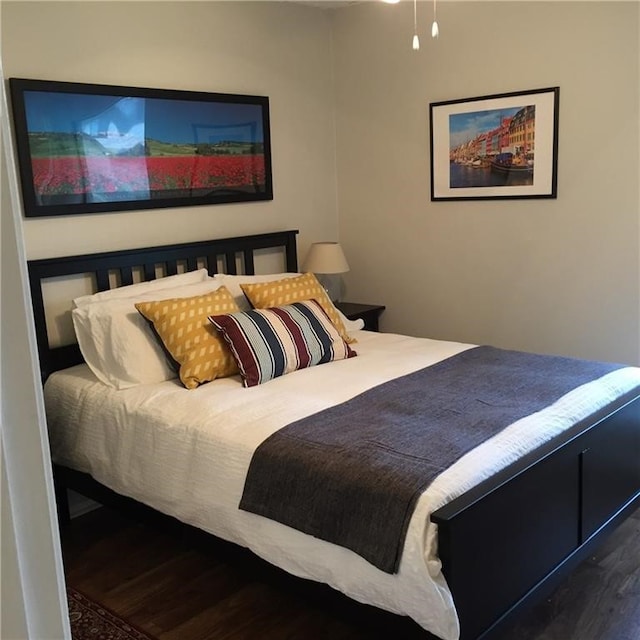 bedroom with dark hardwood / wood-style floors