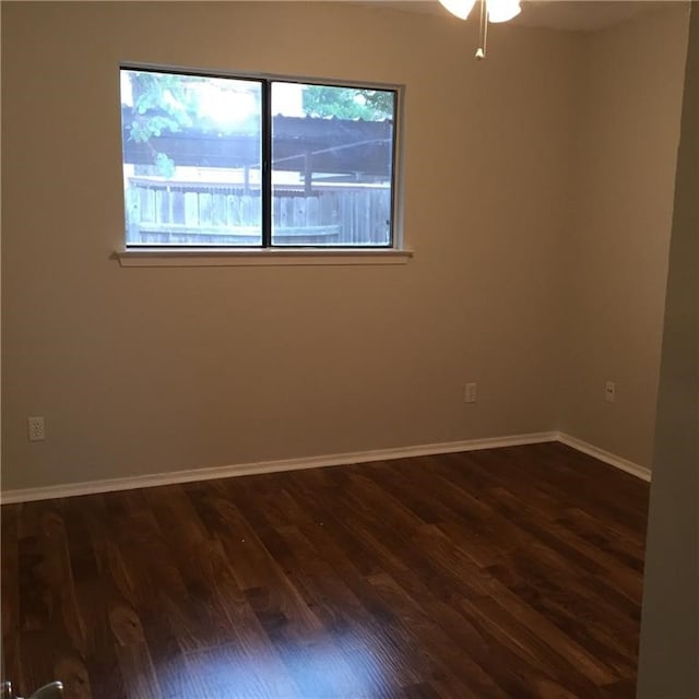 empty room with dark wood-type flooring and ceiling fan