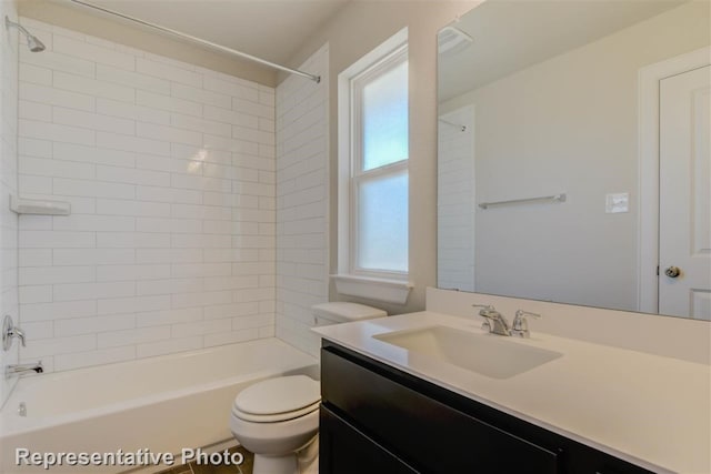 full bathroom featuring vanity, tiled shower / bath combo, and toilet