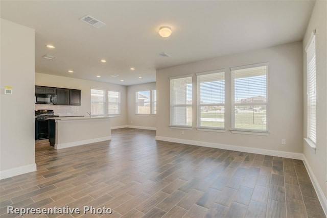 unfurnished living room featuring hardwood / wood-style flooring and plenty of natural light