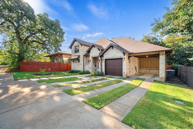 view of front of house with a garage, a carport, a front yard, and central AC unit