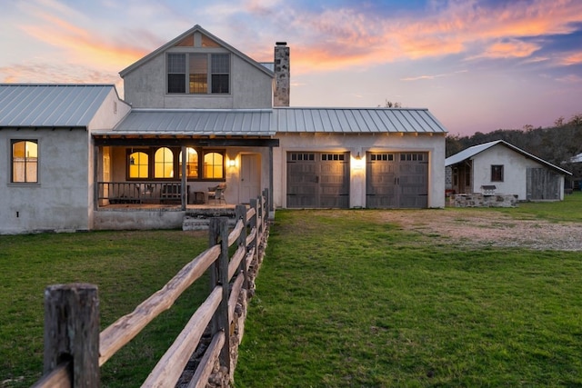 view of front of house featuring a garage, a yard, and covered porch