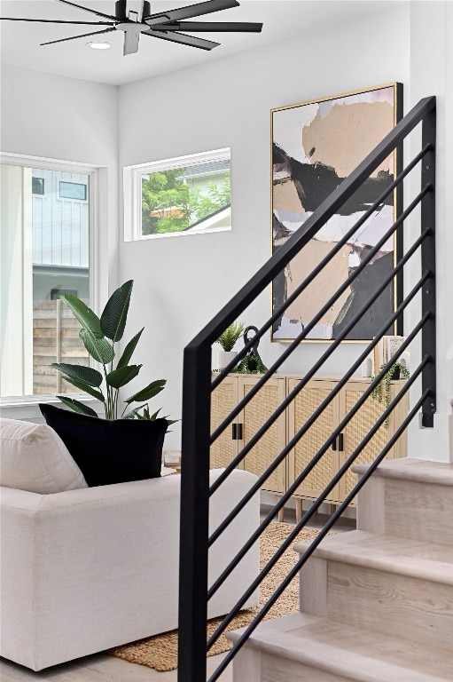 stairway featuring ceiling fan