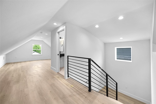 bonus room with lofted ceiling and light hardwood / wood-style flooring