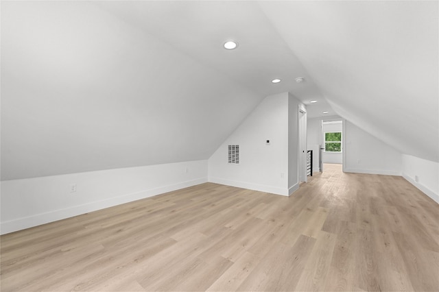 bonus room with vaulted ceiling and light wood-type flooring