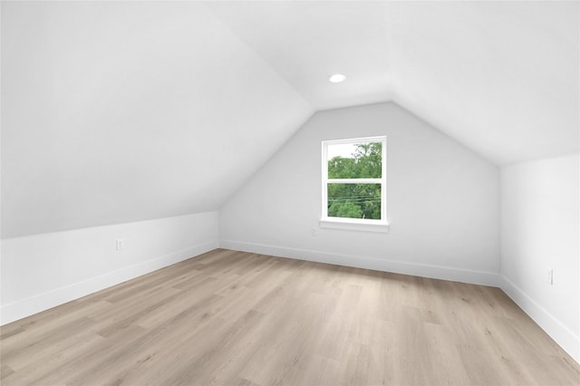 bonus room with vaulted ceiling and light wood-type flooring